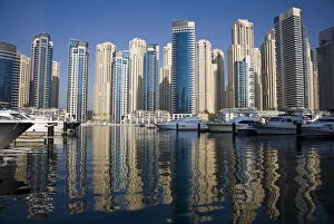 UAE, Dubai. Marina towers with boats at