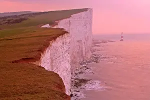 UK - lighthouse at Beachy Head and steep chalk cliffs at sunrise. East Sussex, England, UK