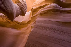 USA - Light that penetrates into the narrow canyon walls creates beautiful hues on the graceful curves of sandstone rock in the Lower Antelope Canyon, probably the most famous slot canyon in the Southwest. Antelope Canyon