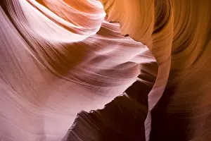 USA - Light that penetrates into the narrow canyon walls creates beautiful hues on the graceful curves of sandstone rock in the Lower Antelope Canyon, probably the most famous slot canyon in the Southwest. Antelope Canyon