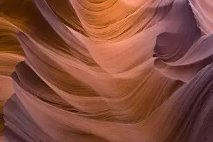 USA - Light that penetrates into the narrow canyon walls creates beautiful hues on the graceful curves of sandstone rock in the Lower Antelope Canyon, probably the most famous slot canyon in the Southwest. Antelope Canyon