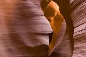 USA - Light that penetrates into the narrow canyon walls creates beautiful hues on the graceful curves of sandstone rock in the Lower Antelope Canyon, probably the most famous slot canyon in the Southwest. Antelope Canyon