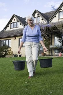 Buckets Gallery: Water conservation - woman walking across lawn