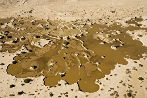 Water from recent rains accumulates in an excavation site where sand is dug up to supply Water from recent rains accumulates in an excavation site where sand is dug up to supply