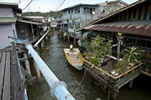 Ayer Gallery: Water Village Walkway with blue water pipe and shacks