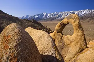 Whitney Portal Arch - rock arch of red granite with snow-capped mountains of the Sierra Nevada behind - Alabama Hills Recreation Area, California, USA