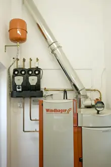 Windhager Austrian wood pellet fired domestic biomass boiler produces heat for thermal store using small wood pellets supplied from a large external hopper installed in small cottage Cotswolds UK