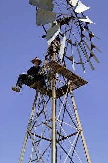 Windmill.Stockman sitting at top of windmill while
