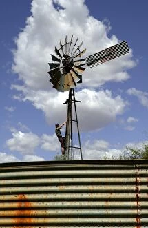 Windmill.with station hand doing maintenance work