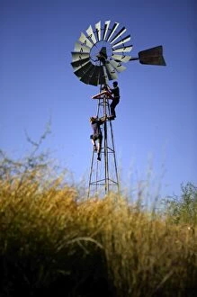 Windmill.with station hands doing maintenance work