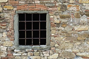 Window with metal bars on ancient stone