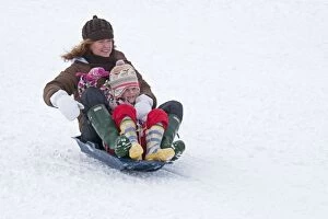 Woman and child sledging in deep snow