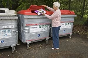 Woman recycling cardboard in recycling bin