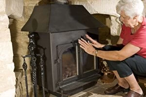 Woman - warming hands on woodstove