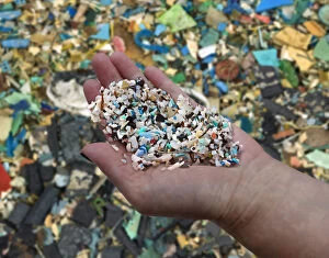 Womans hand showing small pieces of plastic