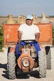 Worker driving tractor - distributes water to the