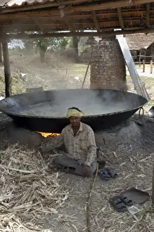 Commercial Prints: Worker - Sugar factory, India. Shows boiling pan in which sugar solution is evapourated to form syrup