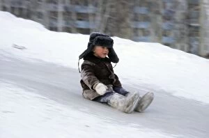 Cardboard Gallery: Young boy does downhill-ice-sliding just on his
