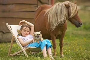 Young Girl - sitting in deckchair with dog and Shetland Pony