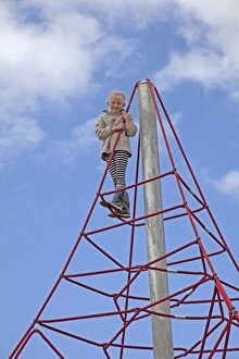 Young girl smiling at top of space climbing net